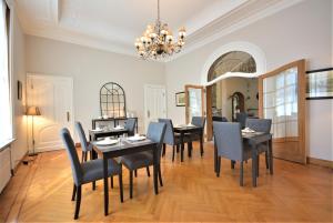 uma sala de jantar com mesas e cadeiras e um lustre em Villa de Noailles em Spa