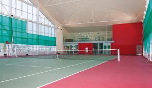 a tennis court with a person standing in a building at Hotel Spolcentrum in Jezersko