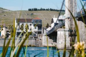 a bridge over a body of water with buildings at Hôtel Les Deux Coteaux in Tain-lʼHermitage