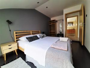 a bedroom with a large white bed and a night stand at Gallery in Rijeka