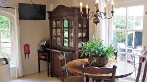 a dining room with a table and a china cabinet at Vakantiewoning Salland in Markelo