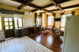 una grande cucina e sala da pranzo con pavimenti e tavoli in legno di Mavie Guest House a Tashkent