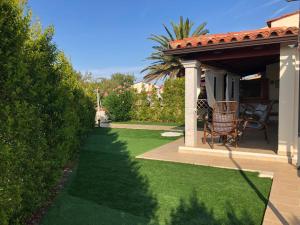 a garden with a gazebo and a chair on the grass at Ca' Viscomi in San Teodoro
