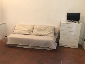 - une chambre avec un lit et une commode avec une télévision dans l'établissement Al Borgo Antico, à Terracine