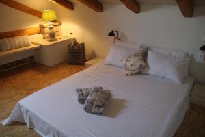a bedroom with a white bed with towels on it at Casa Pietra in Kontokali