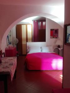a bedroom with a pink bed in a room at Al Giardino Di Alice in Perugia