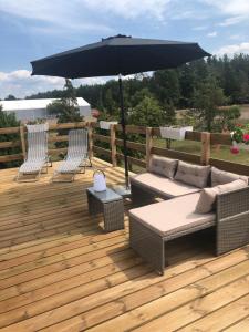 a patio with two chairs and an umbrella at Apartamenty Brzózki in Brzózki