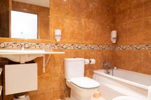 La salle de bains est pourvue de toilettes, d'un lavabo et d'une baignoire. dans l'établissement Hotel las Cruces, à Belmonte de Miranda
