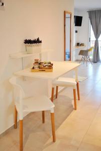 une table et une chaise blanches dans une chambre dans l'établissement El Balconcito Monoambiente, à Saladillo