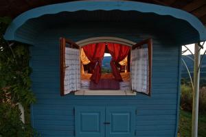 une maison pour chiens bleus avec rideau rouge dans l'établissement La Grande Serve, à La Chabanne