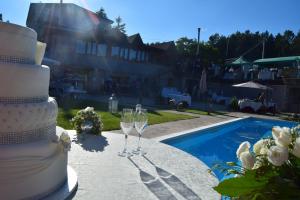 una tarta de boda y copas de vino en una mesa junto a una piscina en La Quercia B&B en San Giovanni in Fiore