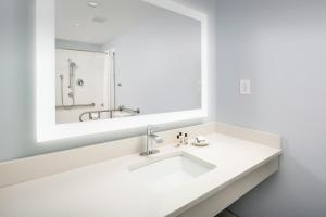 a white bathroom with a sink and a mirror at Ivy City Hotel in Washington