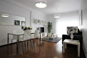 a living room with a table and chairs and a couch at Apartamentos Gaivota Holidays in Nazaré