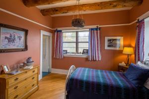 Casa del Gavilan Historic Inn في Cimarron: غرفة نوم بسرير ونافذة