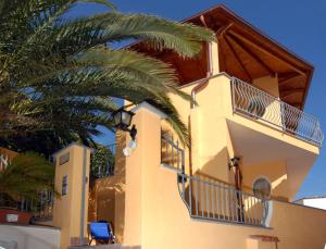 a building with a palm tree in front of it at Arcadia Case e Vacanze in Ischia