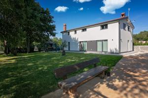 a wooden bench in front of a house at Quercus Apartments - Peace & Nature by the Bike Trail in Funtana