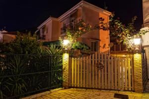 a white fence in front of a house with lights at ANEMOS in Parga