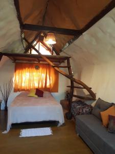 ein Schlafzimmer mit einem Bett und einem Sofa im Dachgeschoss in der Unterkunft Recanto das Corujas in Pirenópolis