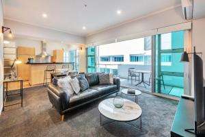 ein Wohnzimmer mit einem Sofa und einem Tisch in der Unterkunft Princes Wharf Boutique Apartments in Auckland
