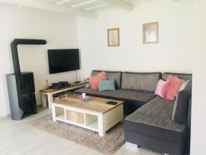 a living room with a couch and a fireplace at Rákóczi12 Vendégház in Hollókő