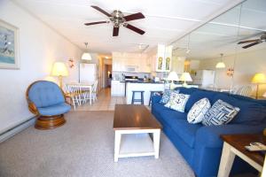 a living room with a blue couch and a kitchen at Breakaway East 109 in Ocean City