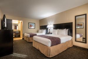 a hotel room with two beds and a mirror at Grand Legacy At The Park in Anaheim