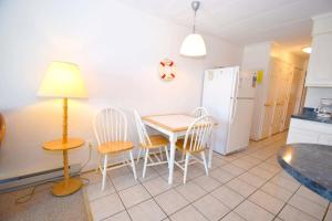 a kitchen with a table and chairs and a refrigerator at Breakaway East 109 in Ocean City