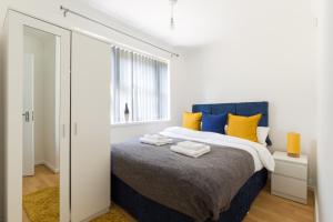 バーミンガムにあるWilfred House Edgbaston - 2 mins fm Cricket gr, QEのベッドルーム1室(黄色と青の枕付きのベッド1台付)