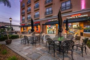 a patio with tables and chairs in front of a building at Grand Legacy At The Park in Anaheim