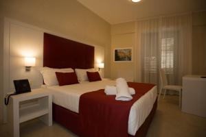 a bedroom with a large bed and a table with a telephone at La Serenissima Hotel in Palermo