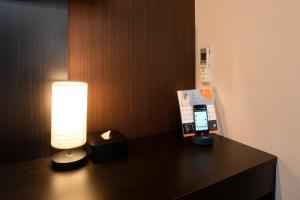 a hotel room with a cell phone on a desk at Hotel Kojan in Osaka