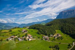 an aerial view of a house in a green field at Ferienbauernhof Wieserhof in Völs am Schlern