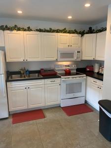 eine Küche mit weißen Schränken und weißen Geräten in der Unterkunft Peaceful Getaway for Two in Lincolnville/Quiet Area/2.3 Miles to Beach in St. Augustine