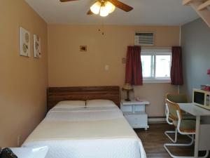 a bedroom with a bed and a desk and a computer at Motel Belair in Rigaud