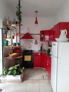 a kitchen with red cabinets and a white refrigerator at Malala Jujuy Hostel in San Salvador de Jujuy