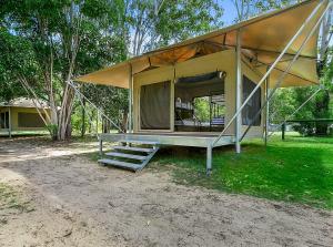 a screened in porch of a house with a porch swing at Habitat Noosa in Cootharaba