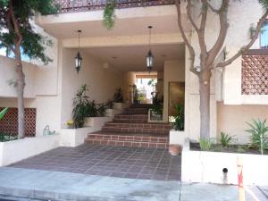 a building with stairs and trees and potted plants at Catalina's Got Cart Condo in Avalon