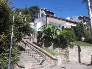 a white house with stairs in front of it at Malala Jujuy Hostel in San Salvador de Jujuy