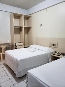 een hotelkamer met 2 bedden en een bureau bij Hotel Danúbio in Belém