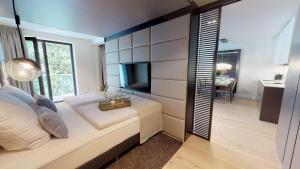 - une chambre avec un grand lit et une télévision dans l'établissement White Pearl Apartment 2.12, à Timmendorfer Strand