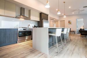 an open kitchen with a counter and bar with stools at Wellington Lake Retreat in Wellington East