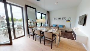 - une salle à manger et un salon avec une table et des chaises dans l'établissement White Pearl Apartment 4.03, à Timmendorfer Strand