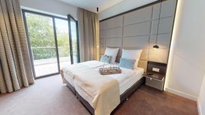 1 dormitorio con cama y ventana grande en White Pearl Apartment 4.20, en Timmendorfer Strand