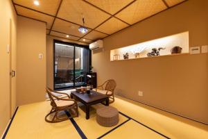 d'un salon avec une table, des chaises et une fenêtre. dans l'établissement Shirakabanoyado - Uchikyuhoji, à Osaka