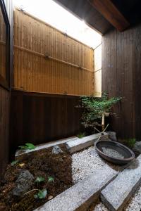 un jardin avec une clôture en bois et un arbre dans l'établissement Shirakabanoyado - Uchikyuhoji, à Osaka