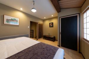 1 dormitorio con 1 cama grande y puerta negra en Shirakabanoyado - UCHIKYUHOJI, 白樺の宿 - 堂庭, en Osaka