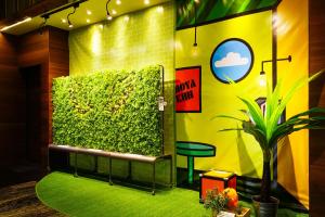 a green wall with a bench and a plant at Hoya Resort Hotel Kaohsiung in Kaohsiung