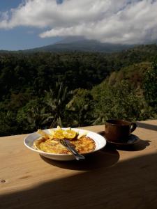 Ein Teller mit Essen und eine Tasse Kaffee auf einem Tisch. in der Unterkunft Rinjani Houseboon in Senaru