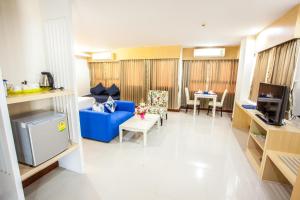 a living room with a blue couch and a tv at Taragrand Donmuang Airport Hotel in Thanyaburi