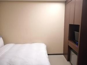 a hotel room with a bed and a tv at Shan-Yue Hotspring Hotel in Taipei